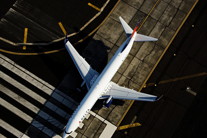 A 737-900 is captured on a runway with a full-body overhead view.